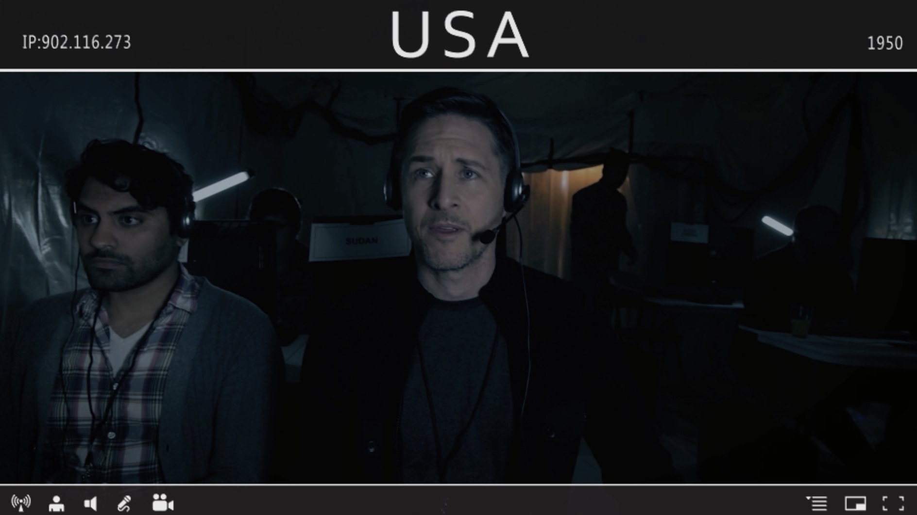 Screenshot of an in-fiction video transmission from the Arrival ARG, showing a dimly lit operations room, with Yuri Lowenthal as Dr. Aaron Walker and Nardeep Khurmi as Arjun.